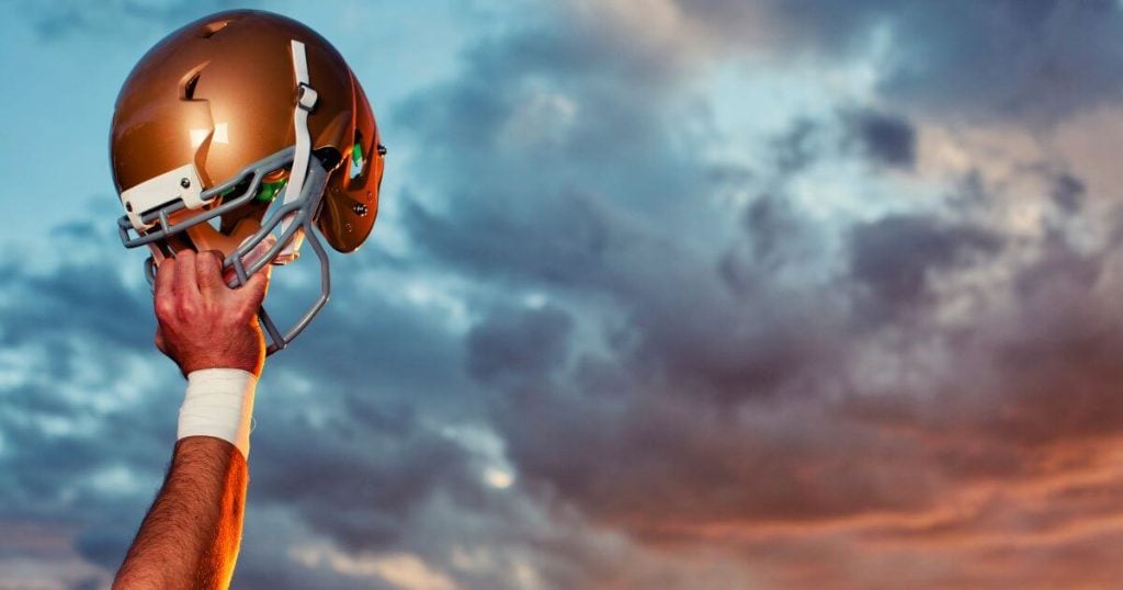 heavy football helmet held in hand by an athlete